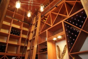 Custom wooden racking and a rolling ladder in a beautiful wine cellar