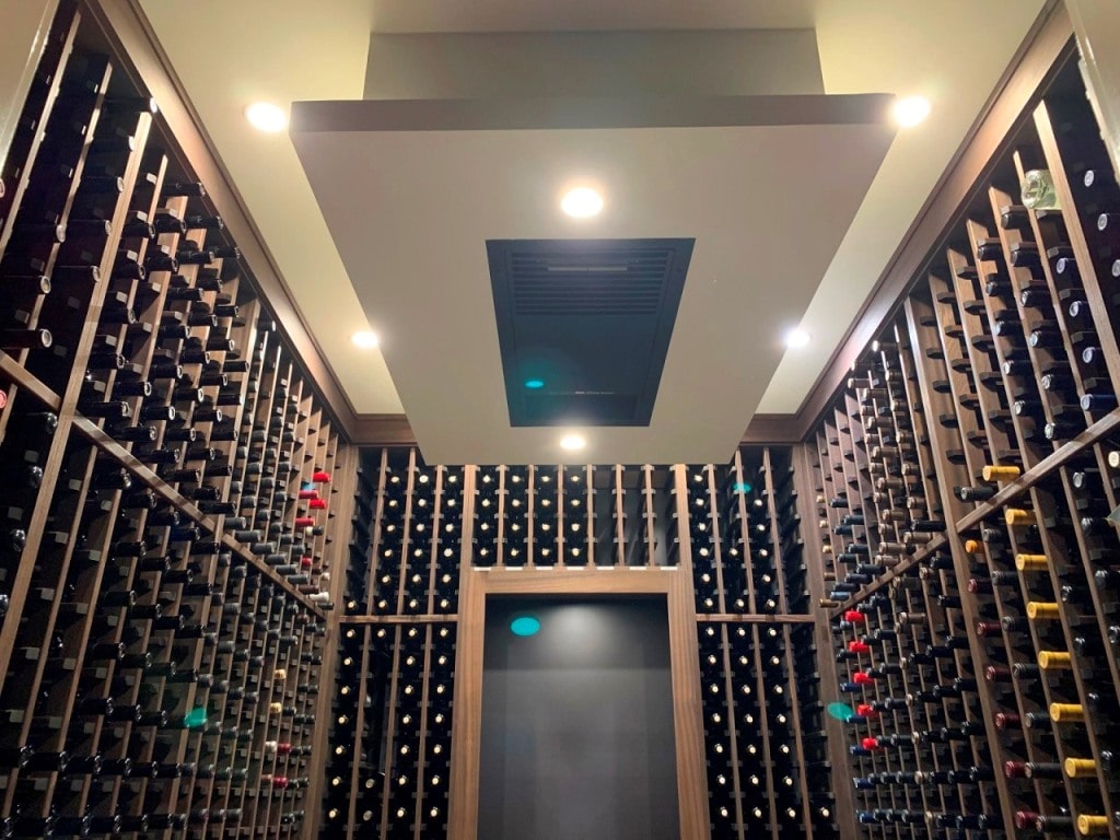 Ceiling Mounted WhisperKOOL Cooling Unit Installed in a Transitional Home Wine Cellar