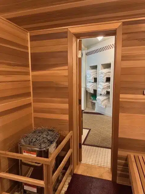 Harvia heater and open locker-room door inside the finished commercial sauna