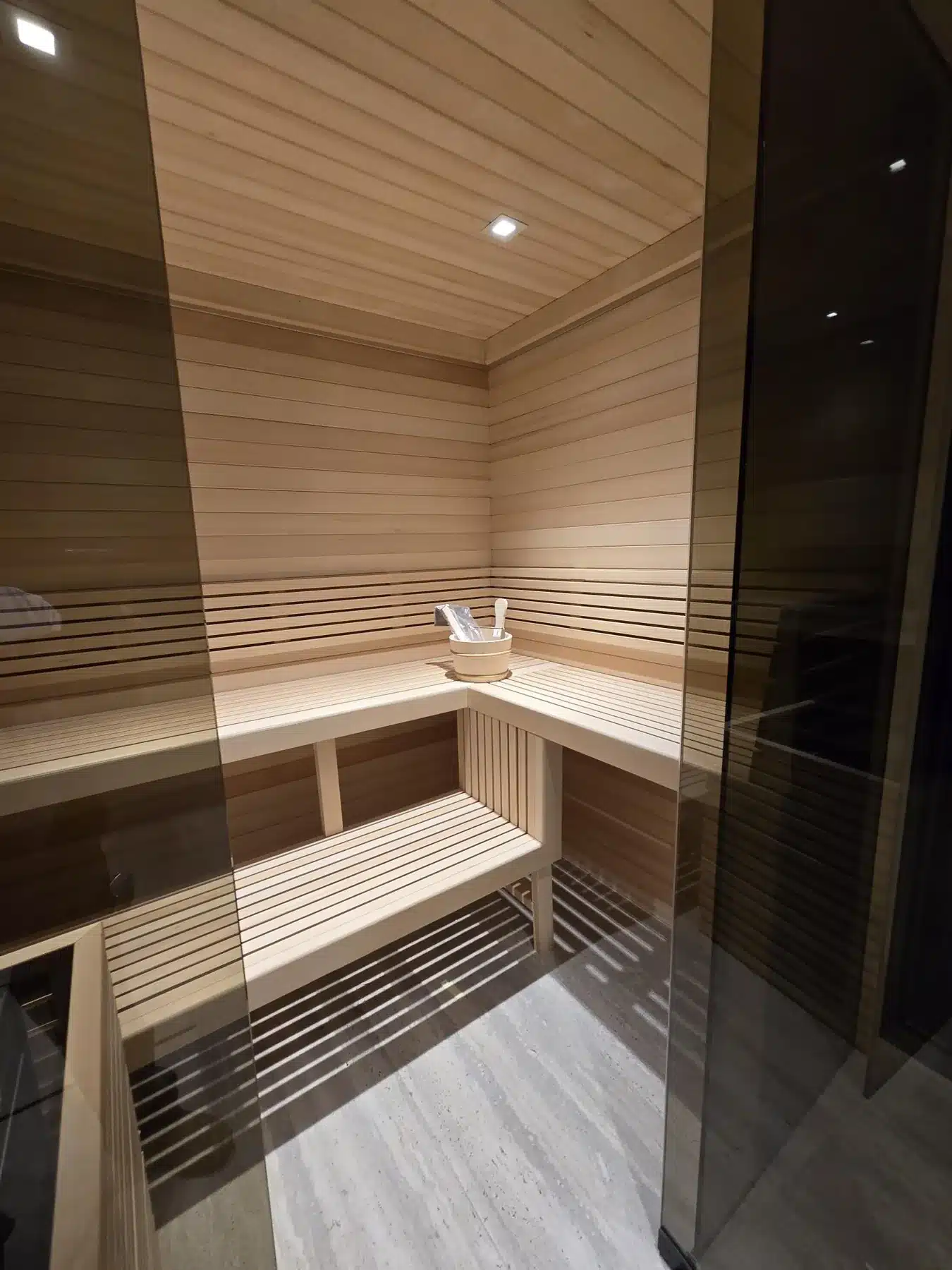 Straight-line Alaska Yellow Cedar benches behind the sauna glass
