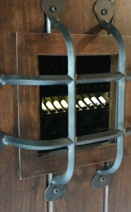 This wine cellar door features a decorative iron grille.