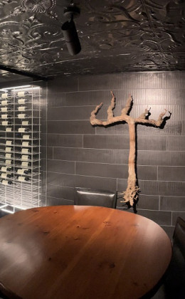 This custom piece of artwork was created from a grape vine, and ties in perfectly with this contemporary wine cellar design.