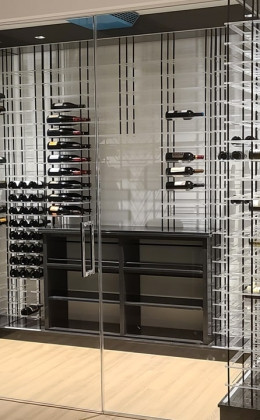A frameless glass door in this modern wine cellar makes it very easy to see inside.